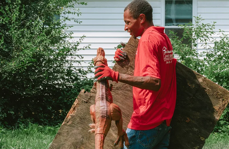 Residential junk removal worker carrying unwanted items